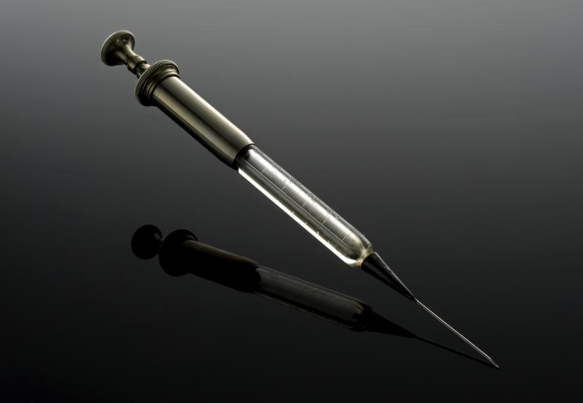 Hypodermic syringe, c.1860. Black perspex background.