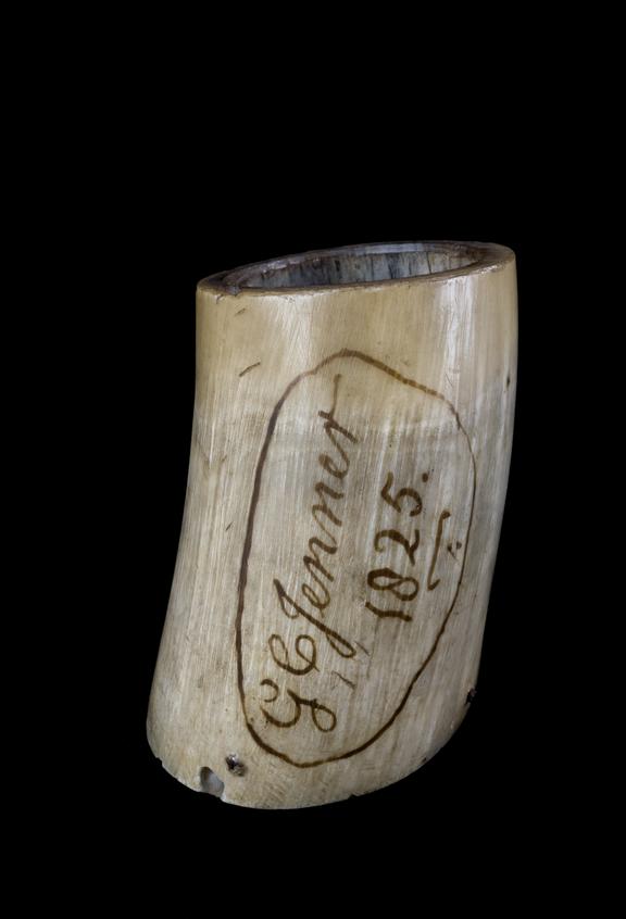 Cow's horn, inscribed "G.C. Jenner.1825". Black background.