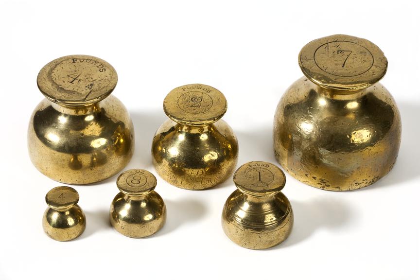 3/4view of a set of six metal weights on a white background.