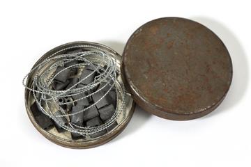 Small circular metal tin of electricity meter security seals