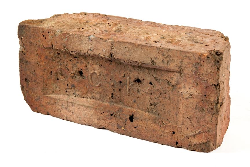 Brick engraved 'CK'.Photographed 3/4 view on a white background.