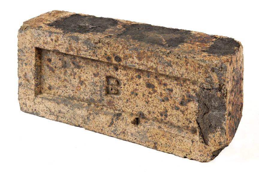 Brick engraved 'B'.Photographed 3/4 view on a white background.