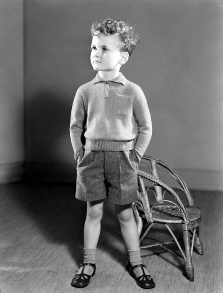 Boy standing next to a chair