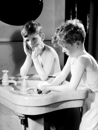 Two boys washing at a sink