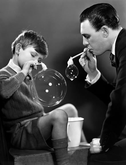 Boy and man blowing bubbles