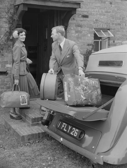 Couple carrying luggage from a car