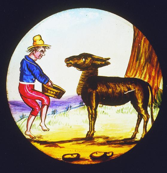Magic lantern slide: Man feeding a donkey | Science Museum Group Collection
