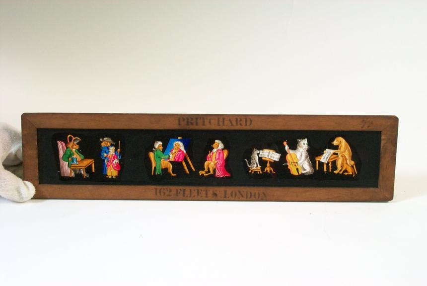 Panoramic magic lantern slide showing four scenes featuring animals dressed as humans