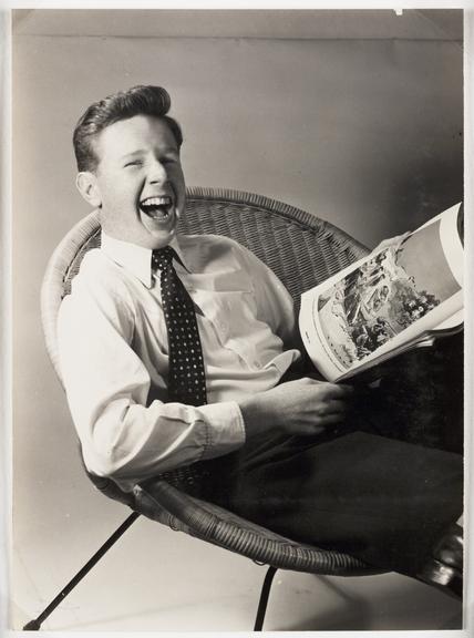 Boy laughing whilst reading