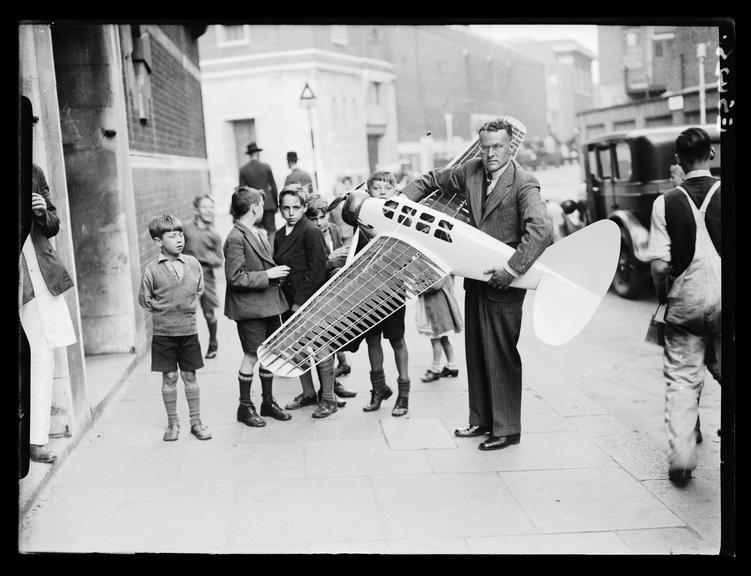 Model aeroplane
    A photograph of a man carrying a model