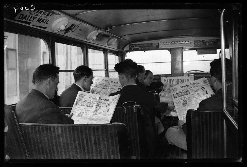 Bus passengers reading the Daily Herald newspaper
    A photograph