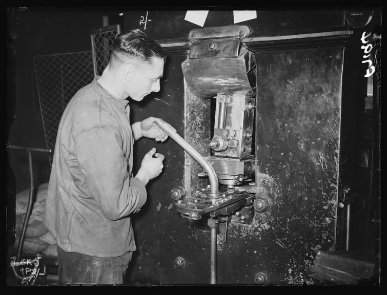 Making coins at the Royal Mint
    A photograph of a worker at the