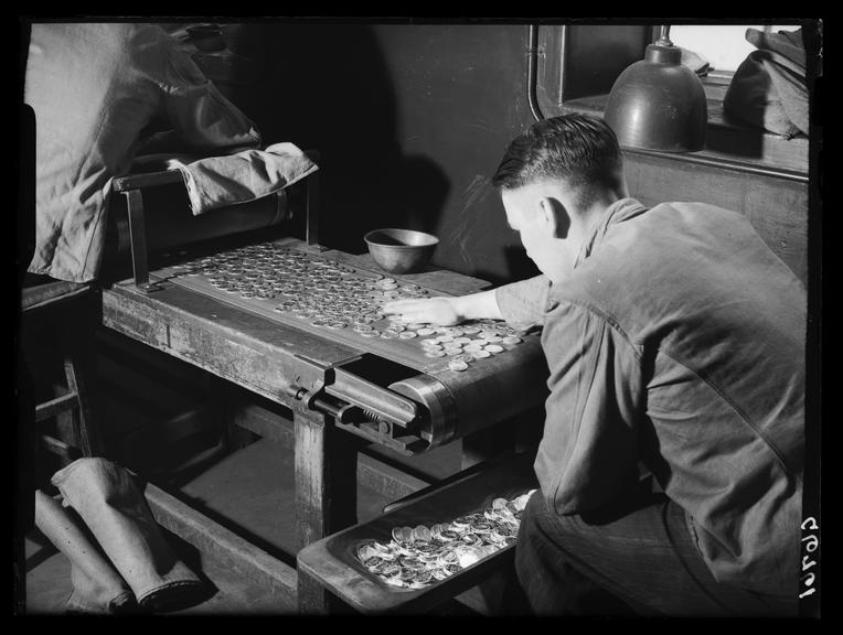 Making coins at the Royal Mint
    A photograph of a worker at the