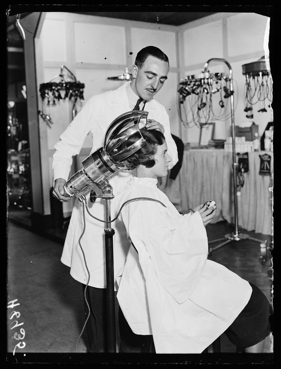 Woman sitting under a hairdryer
    A photograph of a woman