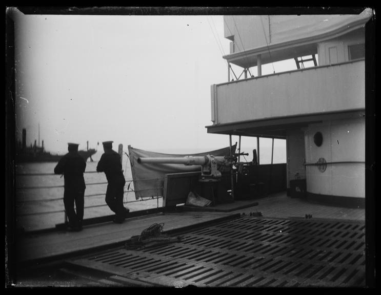 'Two Sailors On Deck Next To Gun Battery'