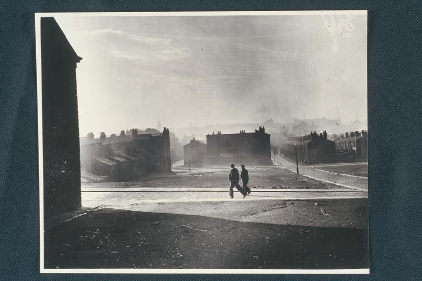 'Two figures walk by cleared blitz site, Liverpool'