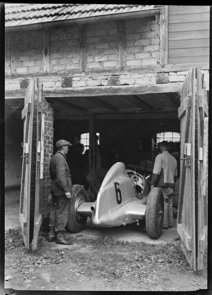 Mechanics working on racing car in Mercedes-Benz team garages