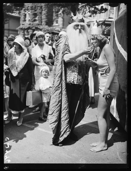 Father Neptune lights a cigarette for Miss Eastbourne