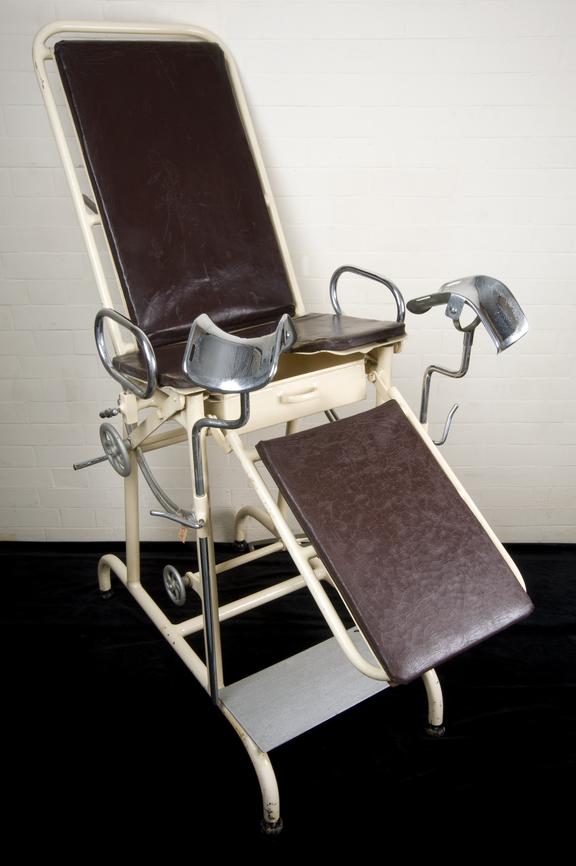 Adjustable gynaecological chair with hand grips and leg rests