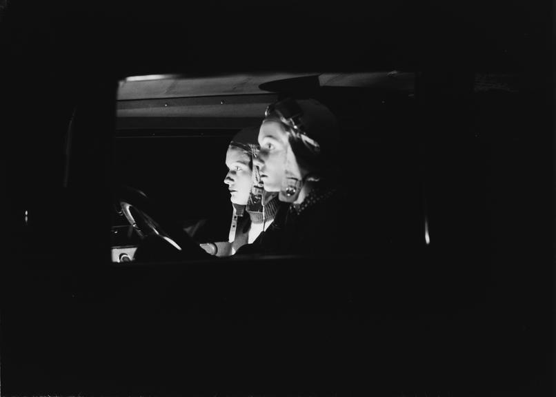 Side view of two women in a car at night