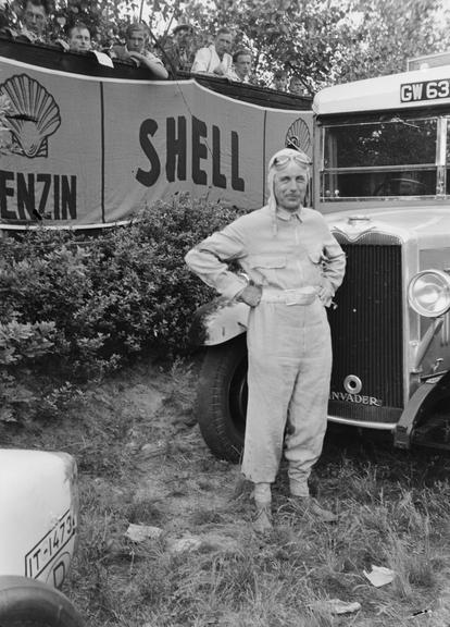 Racing driver in front of large vehicle