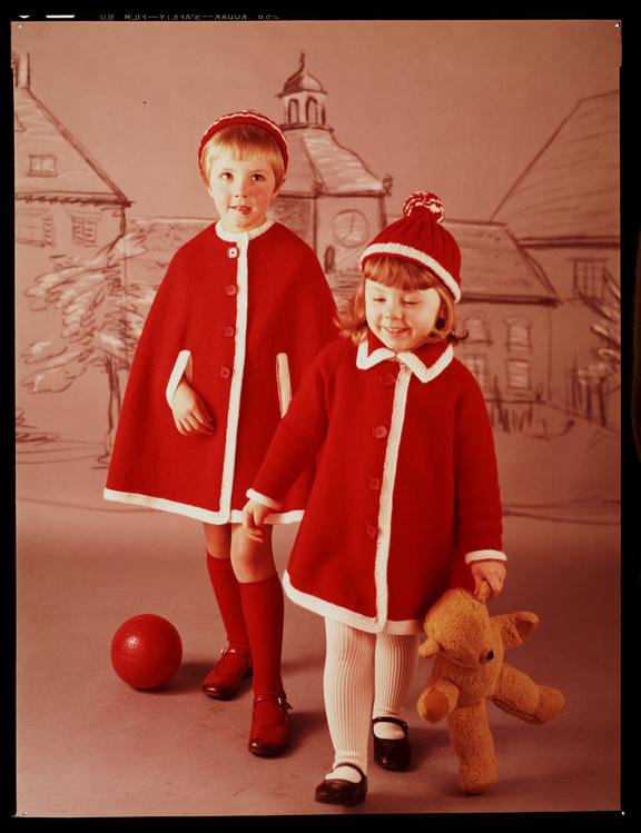 Two children in red and white knitted outfits