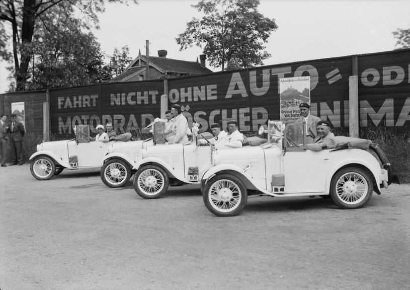 Drivers posing in four cars