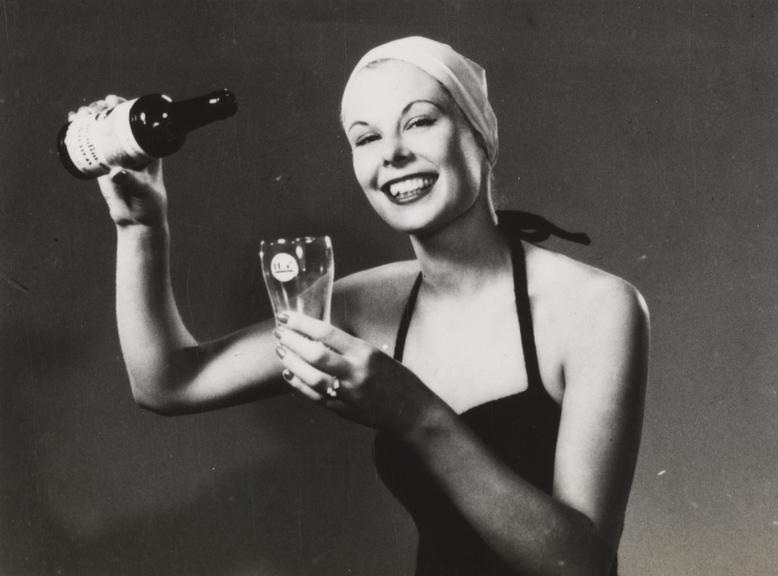 Woman in bathing costume pours a drink