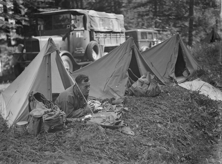 Man in a tent next to mountain road