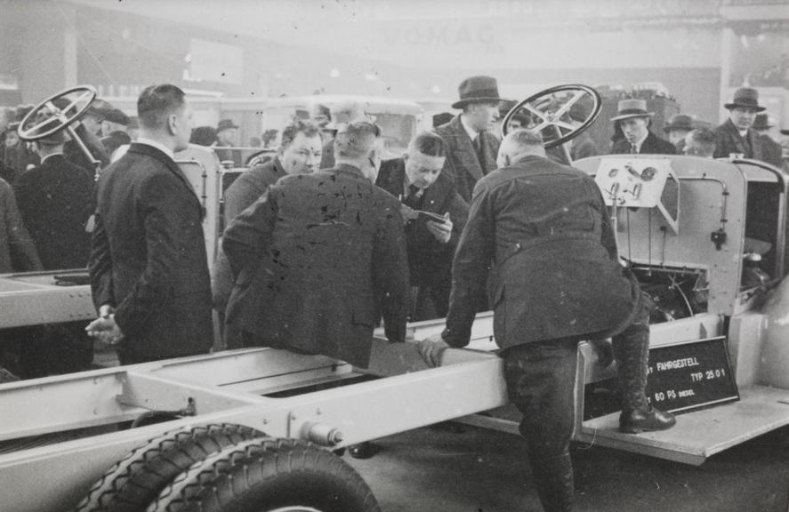 Men gathered around a vehicle chassis