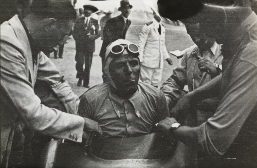 Mechanics assisting Tazio Nuvolari out of his car