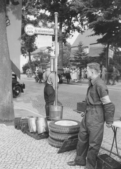 Mechanics wait beside side of car race course