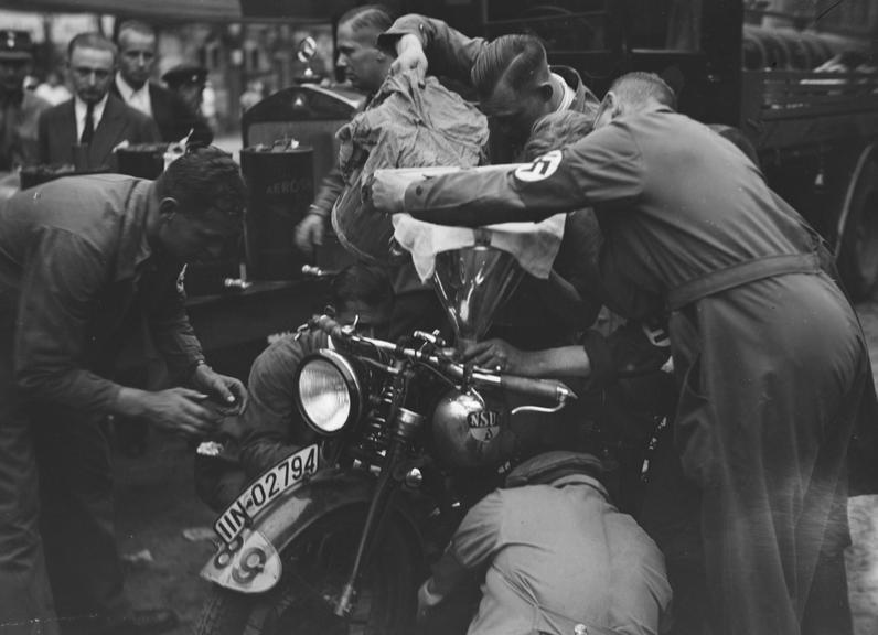 Men prepare motorcycle for race