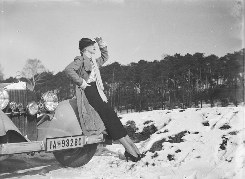 Woman poses with Mercedes Benz car in snow