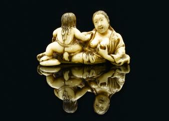 Ivory netsuke showing a mother breastfeeding a child