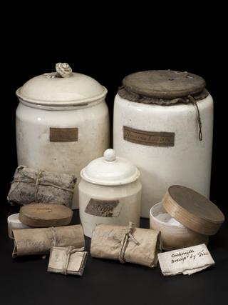 White ceramic jar with leather lid, labelled "Smyrna Lizari"