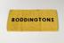 Yellow bar towel bearing the word 'Boddingtons'