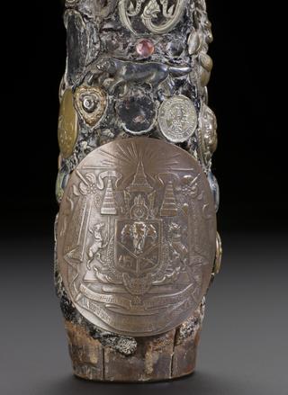 Tobacco pipe, encrusted with coins, buttons, badges, shells, plaques and crests