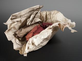 Bundle of red cloth wrapped in paper labelled