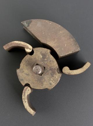 Brass casting, roughly cylindrical, three sinkings in surface