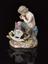 Porcelain figure depicting a satyr playing pipes to a child in