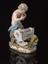 Porcelain figure depicting a satyr playing pipes to a child in