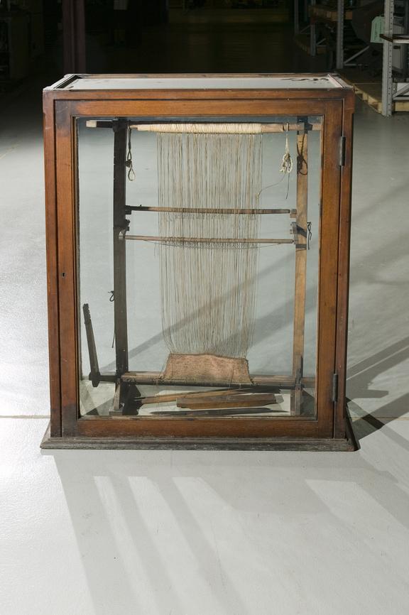 Model of Indian hand loom in a glass case