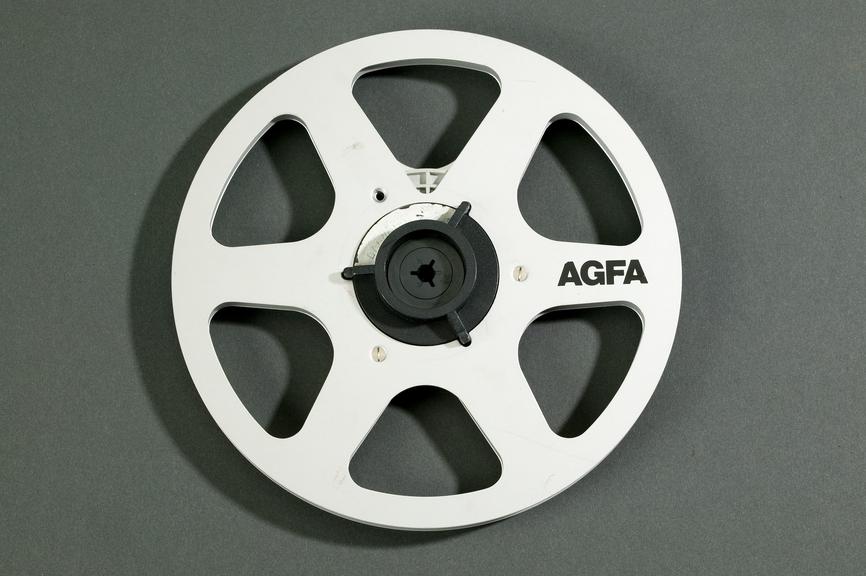 Tape reel, made by Agfa AG.
Photographed on a grey background.