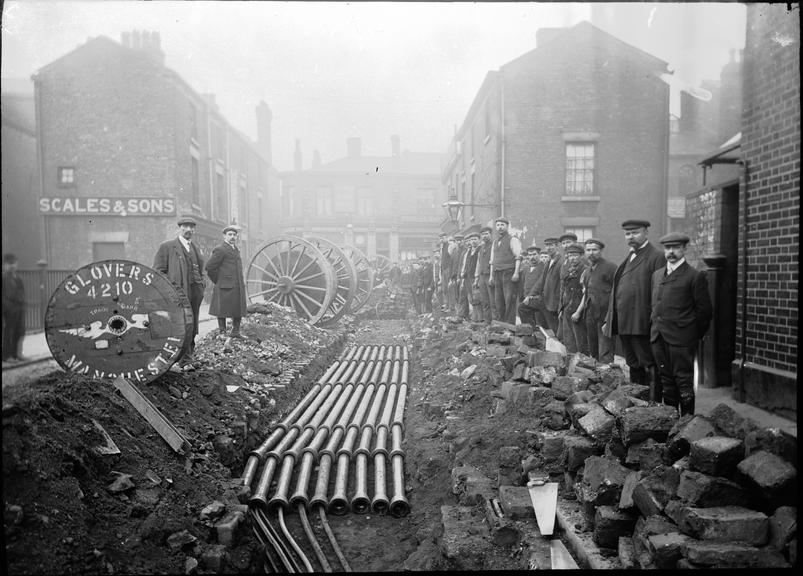 Works photographic negative of men with cables in conduit