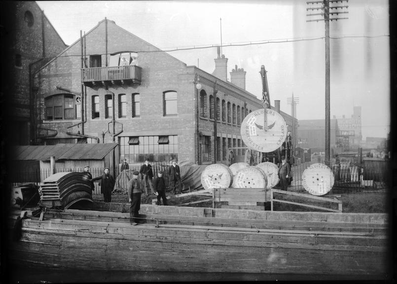 Works photographic negative of cable drums being loaded onto