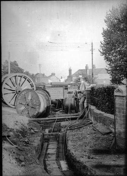 Works photographic negative of cables in suburban street