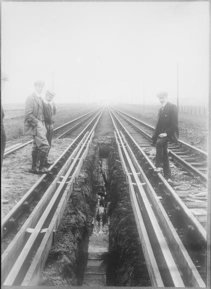 Works photographic negative of cables in trench along railway