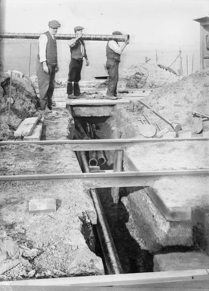 Works photographic negative of trench under railway tracks