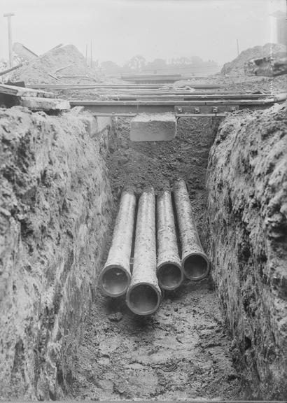 Works photographic negative of trench under railway tracks